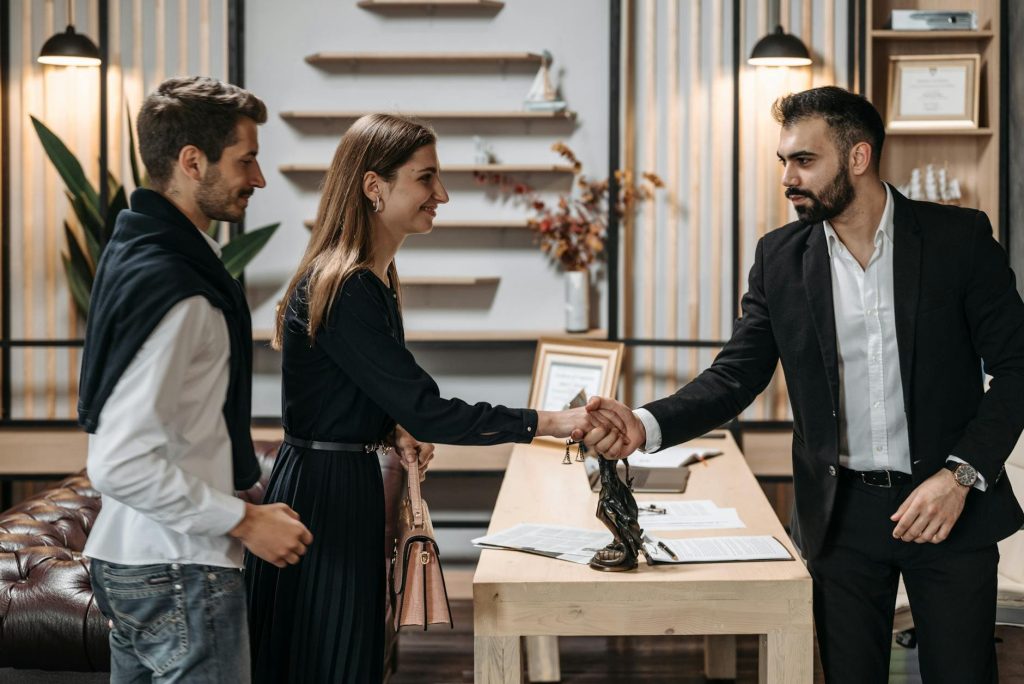 A confident legal professional shaking hands with a client in a modern Nairobi law office, symbolizing trust and expert legal representation at Morsan Co